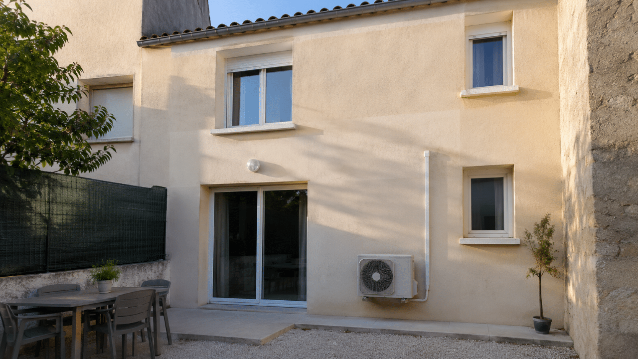 Climatiseur contre un mur en façade arrière d'une maison à Bompas